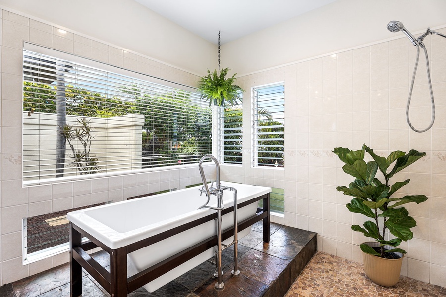 Serene bathroom sanctuary with a deep soaking tub and corner windows, ideal for slow mornings and post-beach resets.