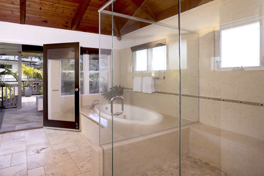 Spa-like ensuite bathroom that is accented with glass enclosed walk-in shower, a large soaking tub and an easy access to the private lanai