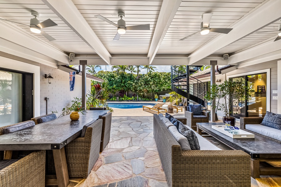 Take a seat under the covered lanai with views of the pool and garden