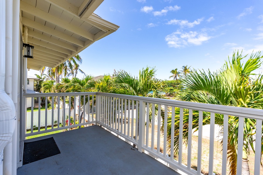 Covered lanai with panoramic views of lush surroundings and blue skies.
