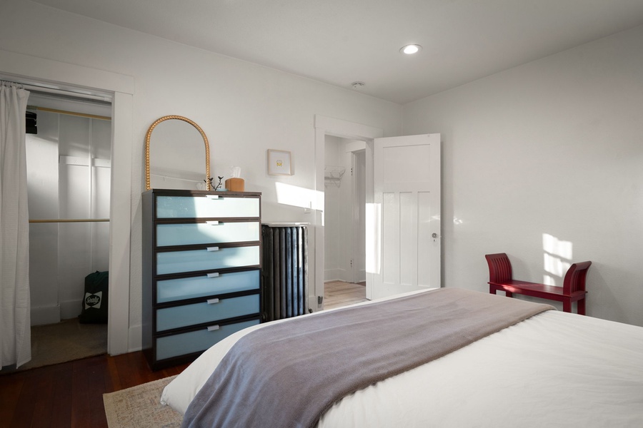 Recharge in this peaceful bedroom with warm wood floors and soft natural light.
