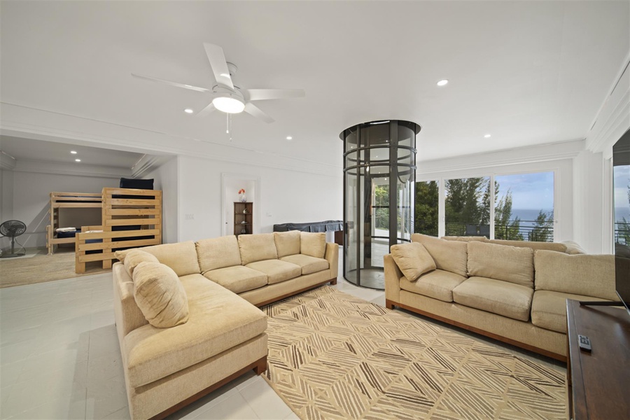 Great room (2nd floor) with wraparound lanai and elevator between the estate’s three stories.