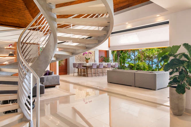 Modern spiral staircase connects two levels of elegance with uninterrupted ocean views.