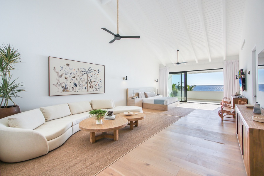 The primary bedroom features a comfortable sofa, king bed and modern decor.