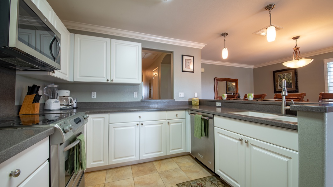 The kitchen features stainless steel appliances and breakfast bar seating.