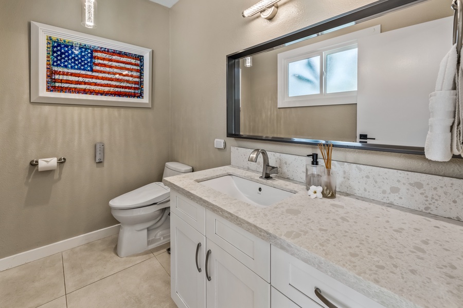 The clean & bright powder room has sing vanity and Toto toilet.