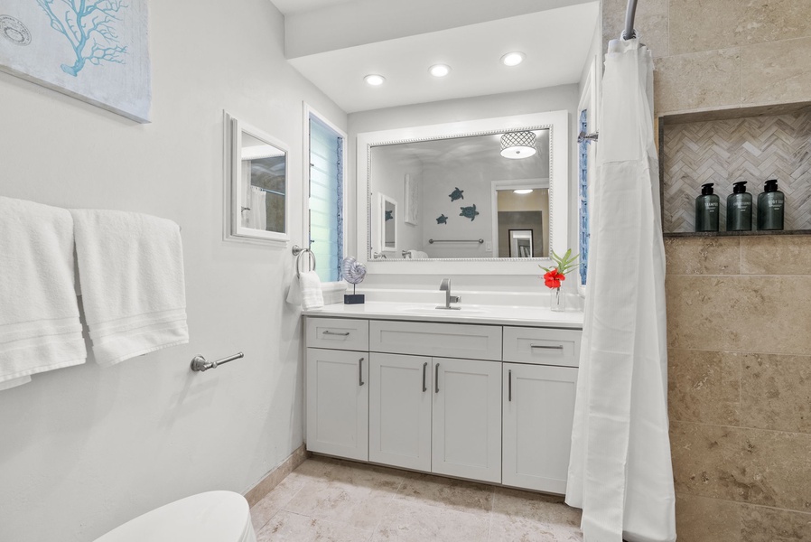 Ensuite bath featuring a generously spaced vanity for added convenience.