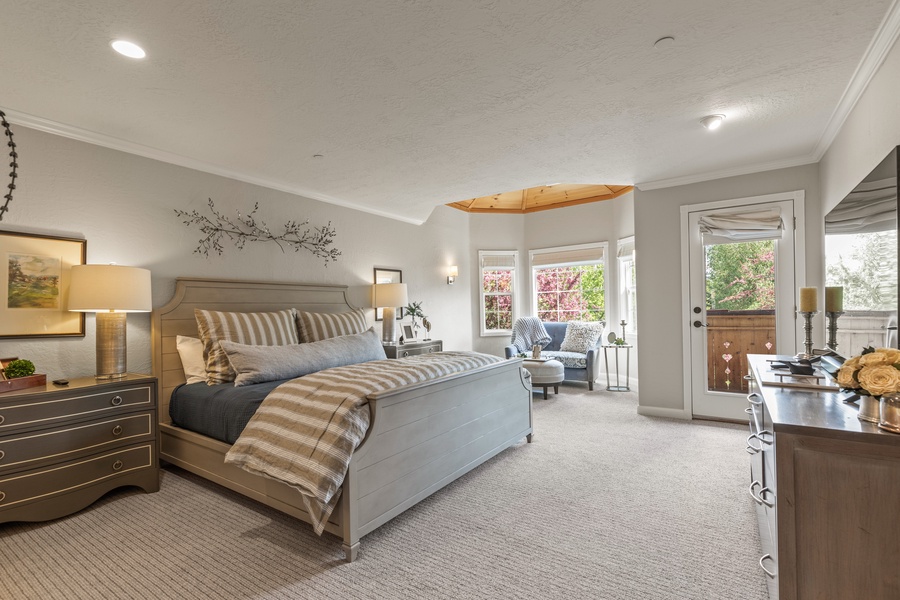 The primary bedroom with king sized bed, showing the access to the balcony