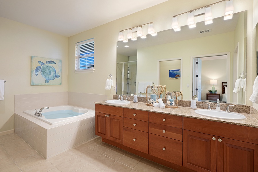 Relax in the primary bathroom soaking tub after a busy island day with dual sinks and ample vanity spaces.
