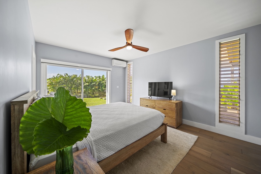 Bright bedroom with a queen-sized bed, natural light, and stylish decor.