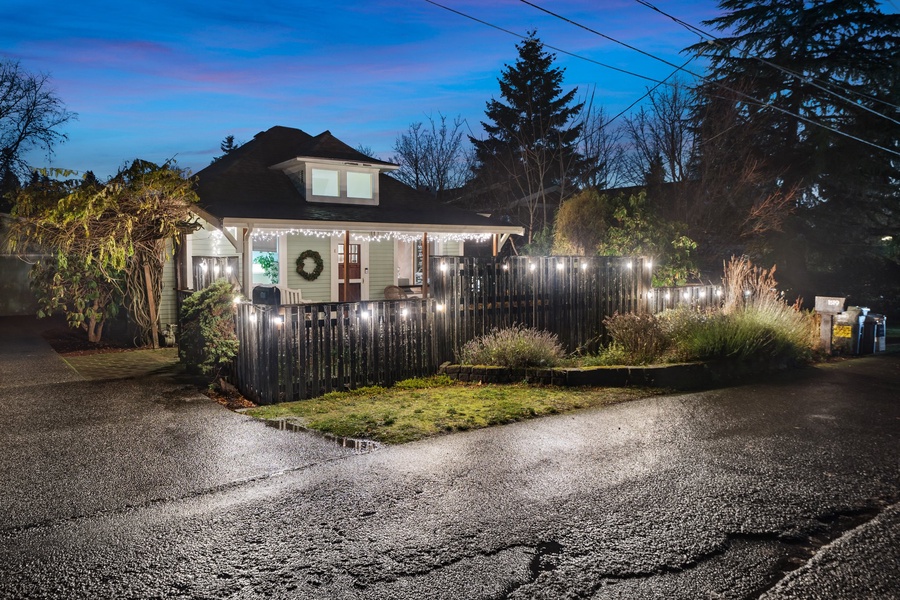 Charming exterior view of the property with holiday lights illuminating the night.