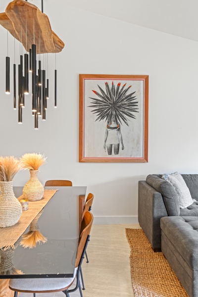 Natural textures and bold island art give the space a relaxed, curated feel.