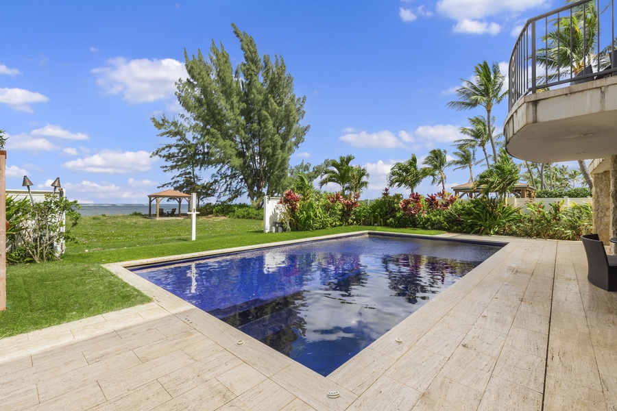 Relax and unwind in this tropical oasis featuring a stunning pool that offers a picturesque backdrop of crystal clear ocean and lush greenery