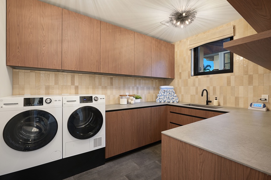 Spacious laundry room with full-size washer and dryer, generous cabinetry, and counter space for extended island stays.