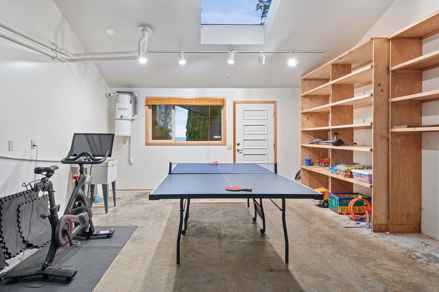 large 2-car garage with a hobby room and carport, a Peloton bike, kayaks, and a ping pong table for added entertainment and enjoyment.