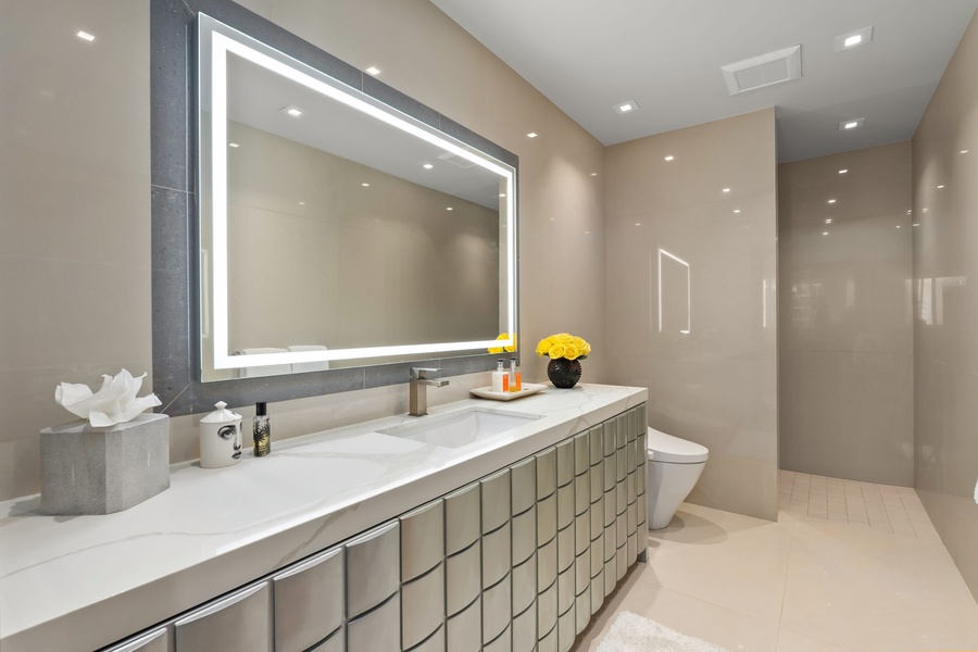 Step into your private spa-like retreat, where elegant tile details and ambient lighting create a serene escape. The sleek vanity and walk-in shower invite you to unwind in modern luxury.