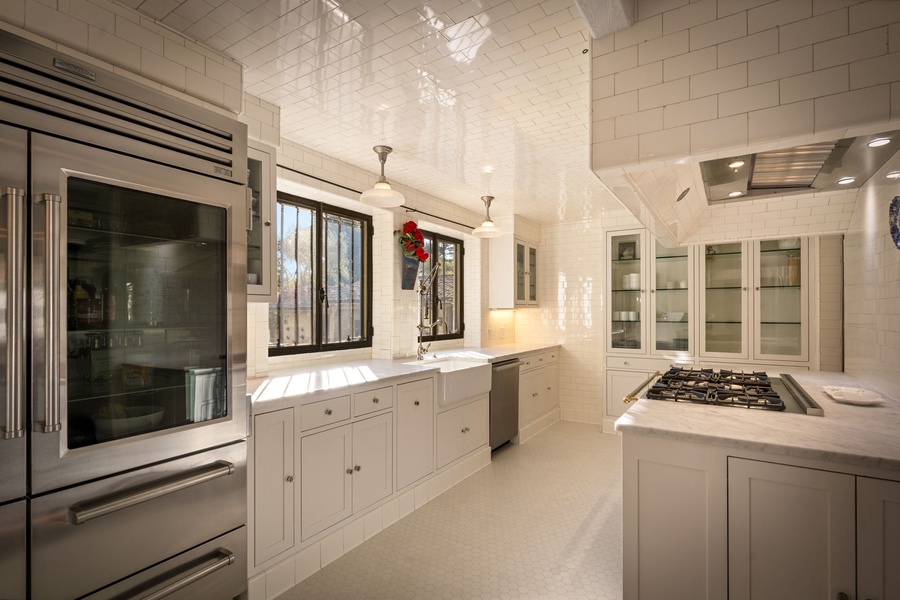 Your spacious chef's kitchen awaits with gleaming subway tile walls, premium stainless steel appliances, and elegant marble countertops for memorable meal preparation.