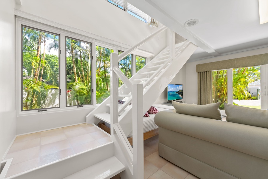 Elegant staircase in the family den with a view of the lush garden, bringing natural beauty indoors.