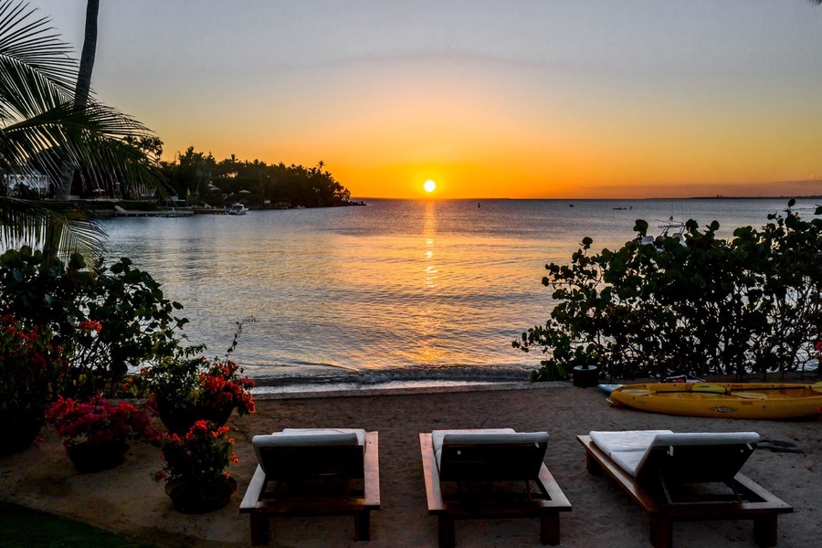 Unwind on beachfront loungers as the sun sets over the tranquil waters.