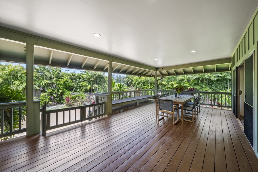 Second lanai dining space overlooking lush tropical foliage—shaded, breezy, and serene.