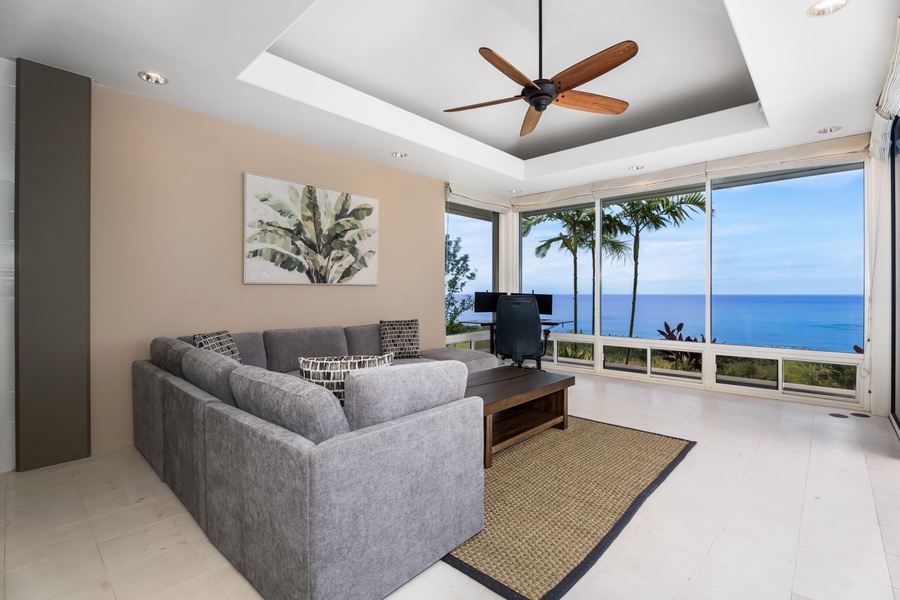 Your private home office lounge opens to stunning ocean views through floor-to-ceiling windows, perfect for relaxing after beach days.