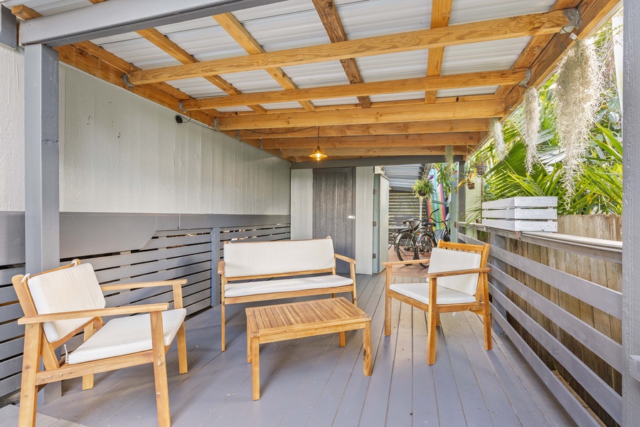 A covered lanai with outdoor seating makes the perfect spot for shaded relaxation or evening drinks.