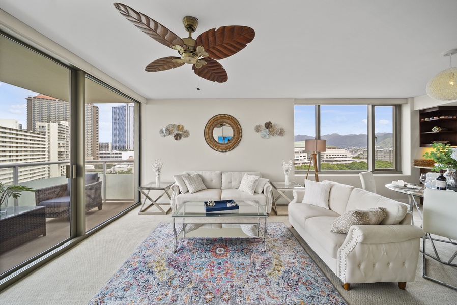 The chic living area has plush sofas, ceiling fan and central AC, outdoor views, and a direct access to the lanai.