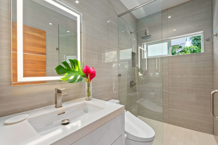 Step into your serene private bathroom with soft natural light, a spacious rainfall shower, and sleek modern design that makes freshening up a luxury.