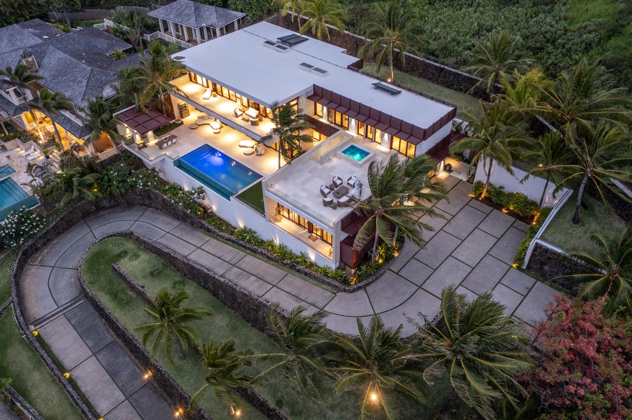 Aerial night view of the illuminated estate, showcasing the pool and luxurious ambiance.
