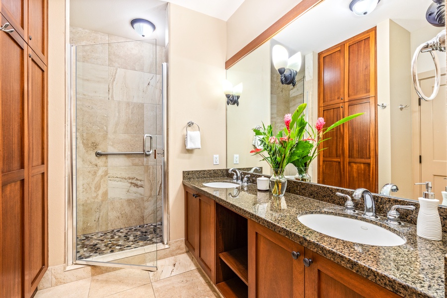 Primary bath with dual sinks, walk-in shower, and W/C area with supportive grab bar handles.