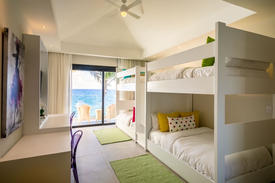 Relax in this vibrant guest bedroom with ocean views and ample space.