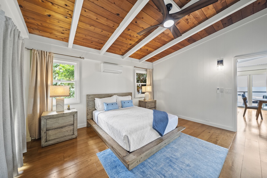 Guest bedroom with a queen bed and cooling A/C—an airy retreat after exploring Haleiwa’s beaches and shops.