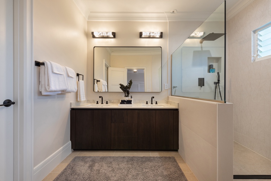 Luxurious bathroom with double vanity, large mirrors, and a walk-in shower.