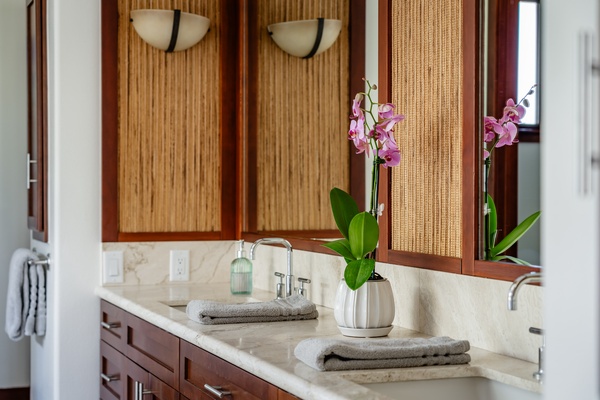 Elegant bathroom with dual sinks, marble countertops, and warm wooden accents, creating a serene and luxurious atmosphere.