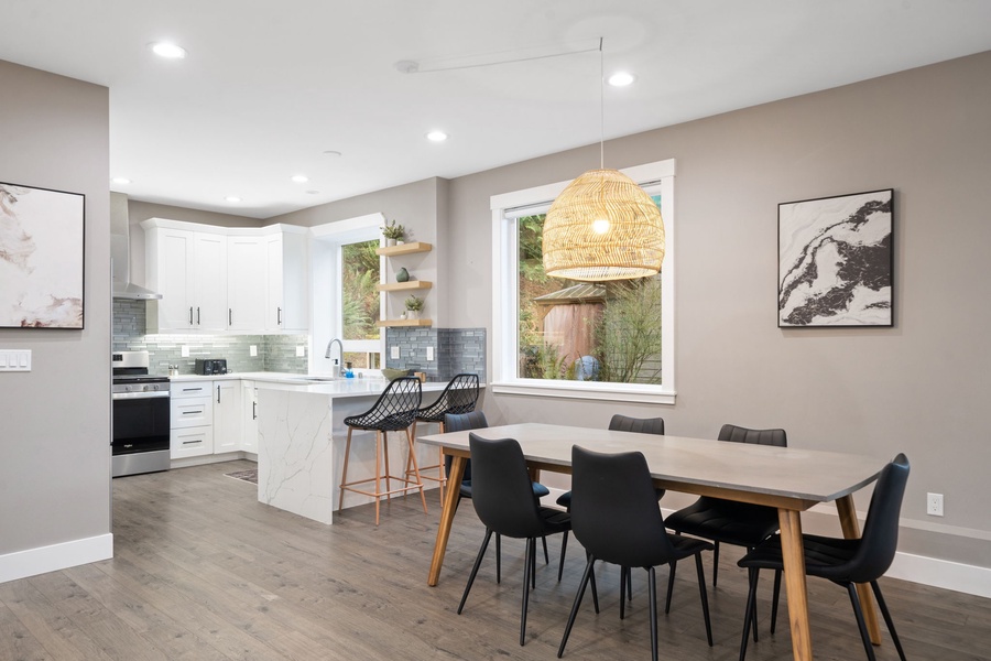 Your open-plan kitchen and dining area blends modern style with warmth, featuring sleek appliances and a beautiful woven pendant light overhead.