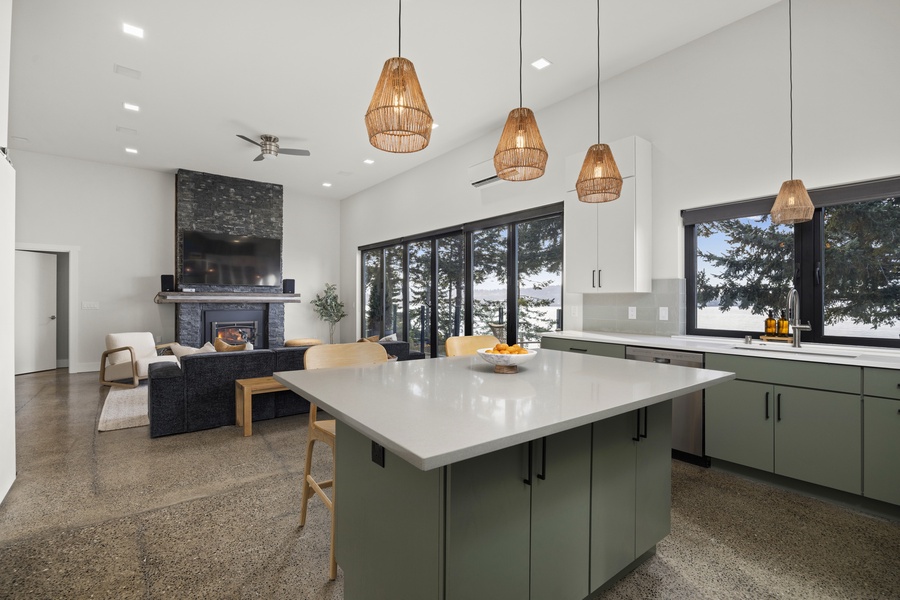 Chef’s kitchen with high-end appliances and a generous island overlooking the bay and living area.