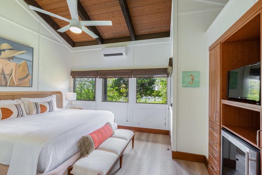 Private exterior-access bedroom with a king bed, vaulted ceilings, and garden views.