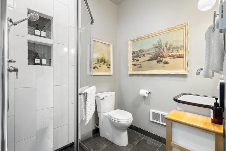 Simple and functional with a warm wood vanity and private water closet setup.