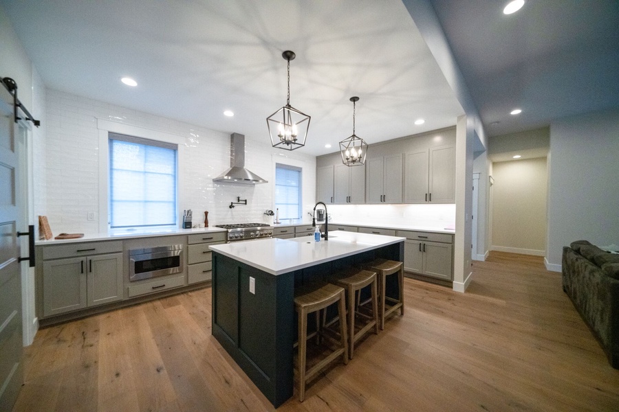 the spacious gourmet kitchen is outfitted with all top-of-the-line stainless steel appliances, ample counter space, and a large island countertop with barstools for any chef to feel right at home while cooking and entertaining