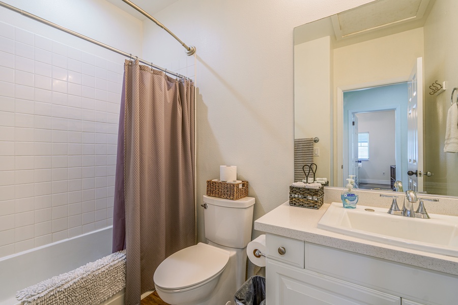 The third guest bathroom features a bright vanity and shower.