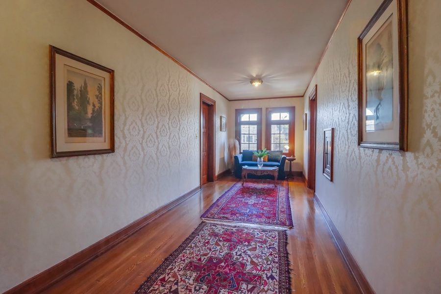 The second level hallway with seating area, guest room 4 is to the right while guest suite 5 is to the left.