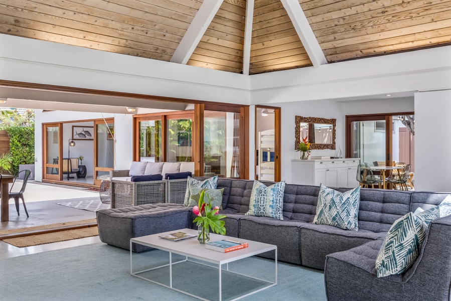 Experience the grandeur of a cathedral ceiling in the living area, complemented by a section of glass roofing, allowing an abundance of natural light to cascade in, illuminating the space beautifully.