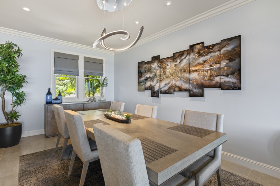 The dining area offers a sophisticated space for meals, featuring elegant decor and modern lighting that complements the room’s neutral tones.