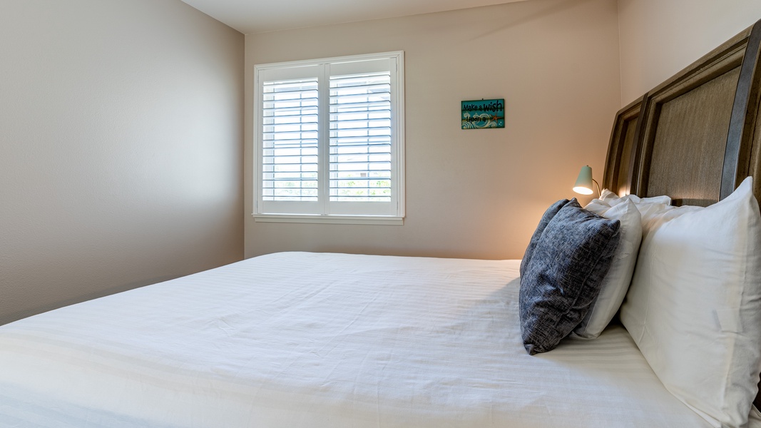 The second guest bedroom with a queen bed and ceiling fan.