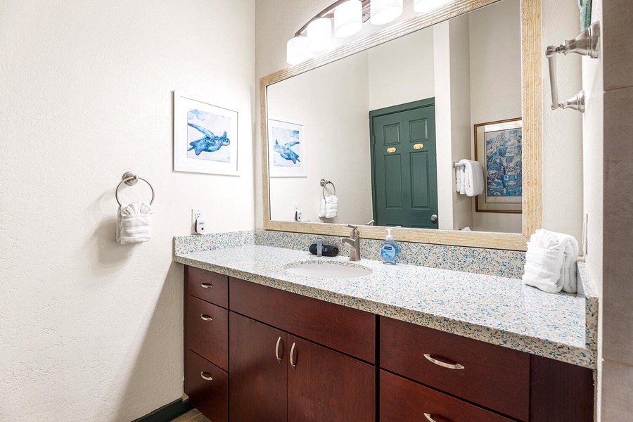 Spacious bathroom with modern finishes, granite vanity, and plush towels for a refreshing start or end to your day.