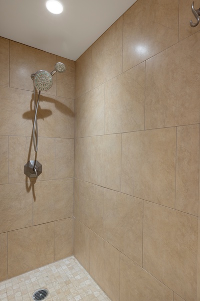 Walk-in shower with tile surround and rainfall head for a soothing rinse.