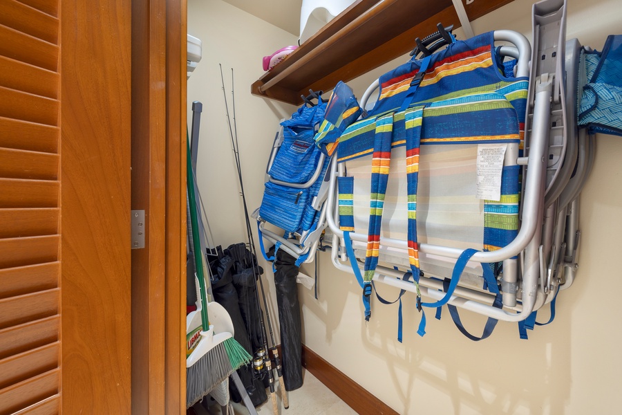 A neatly organized storage closet with beach chairs and fishing rods, ready for outdoor activities.