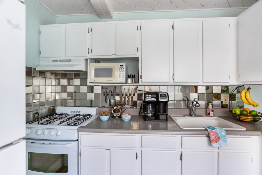 Functional kitchen area with white cabinetry, modern appliances, and a homey feel.