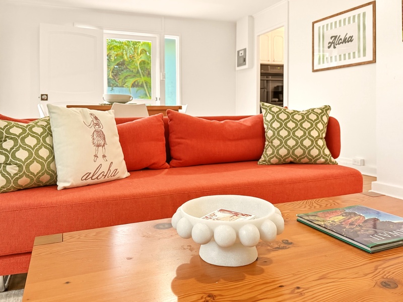 Sink into this vibrant coral sofa with tropical touches, where Hawaiian-inspired decor creates your perfect island retreat lounge.