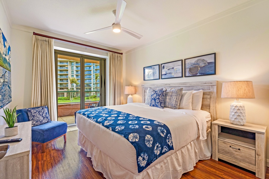 Primary bedroom at Honua Kai Konea 206 opens to lanai and features elegant island décor.